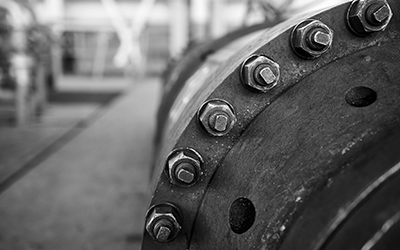 Sealing connection bolted screw connection, on manhole of industrial machine compressor or pump on chemical plant selective focus without of focus abstract industrial background.