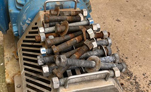 A group of irregular and rusted bolts, washers, and nuts